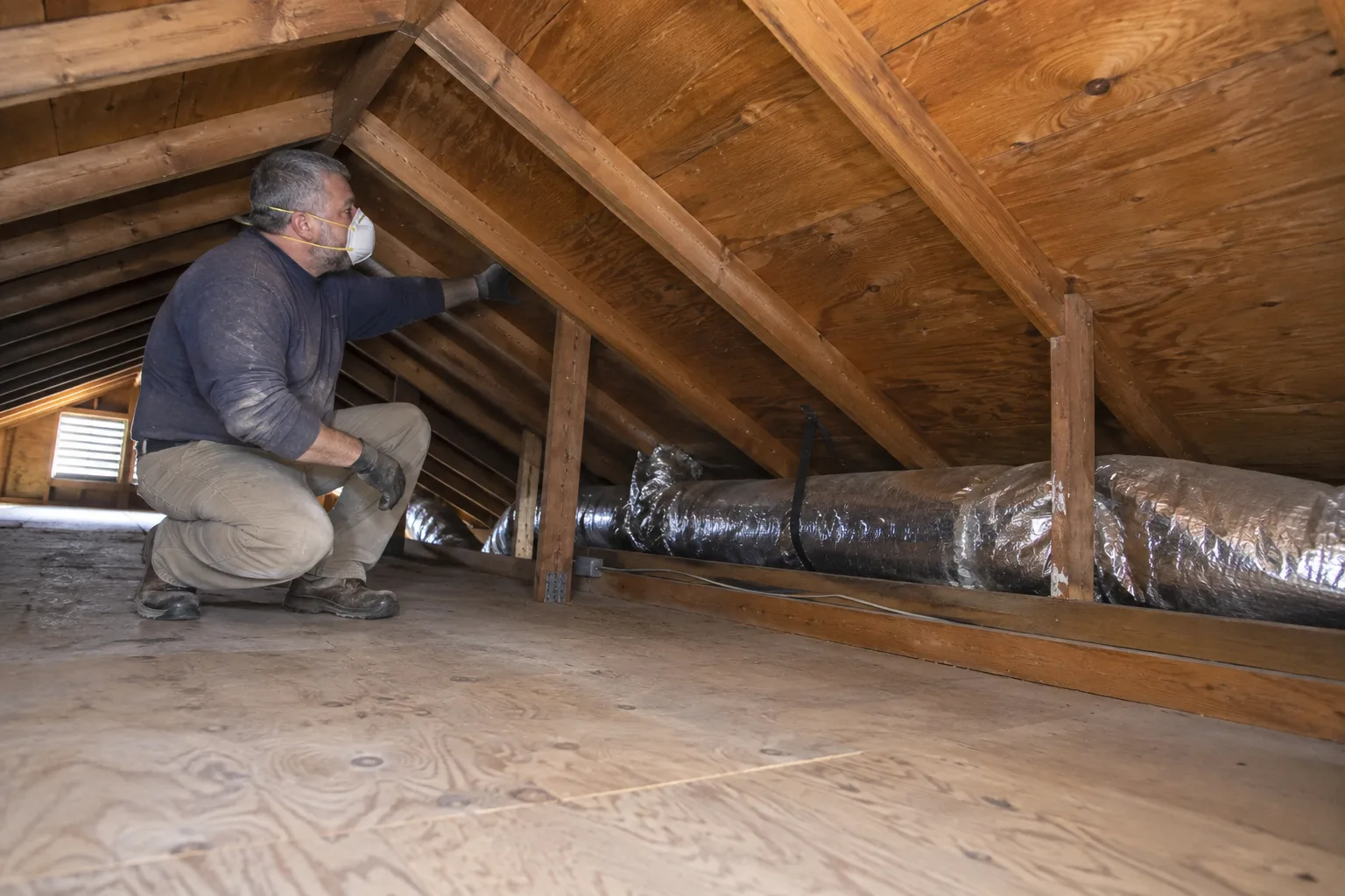 Inspecting attic insulation and ductwork during a clean-up assessment before debris removal begins.