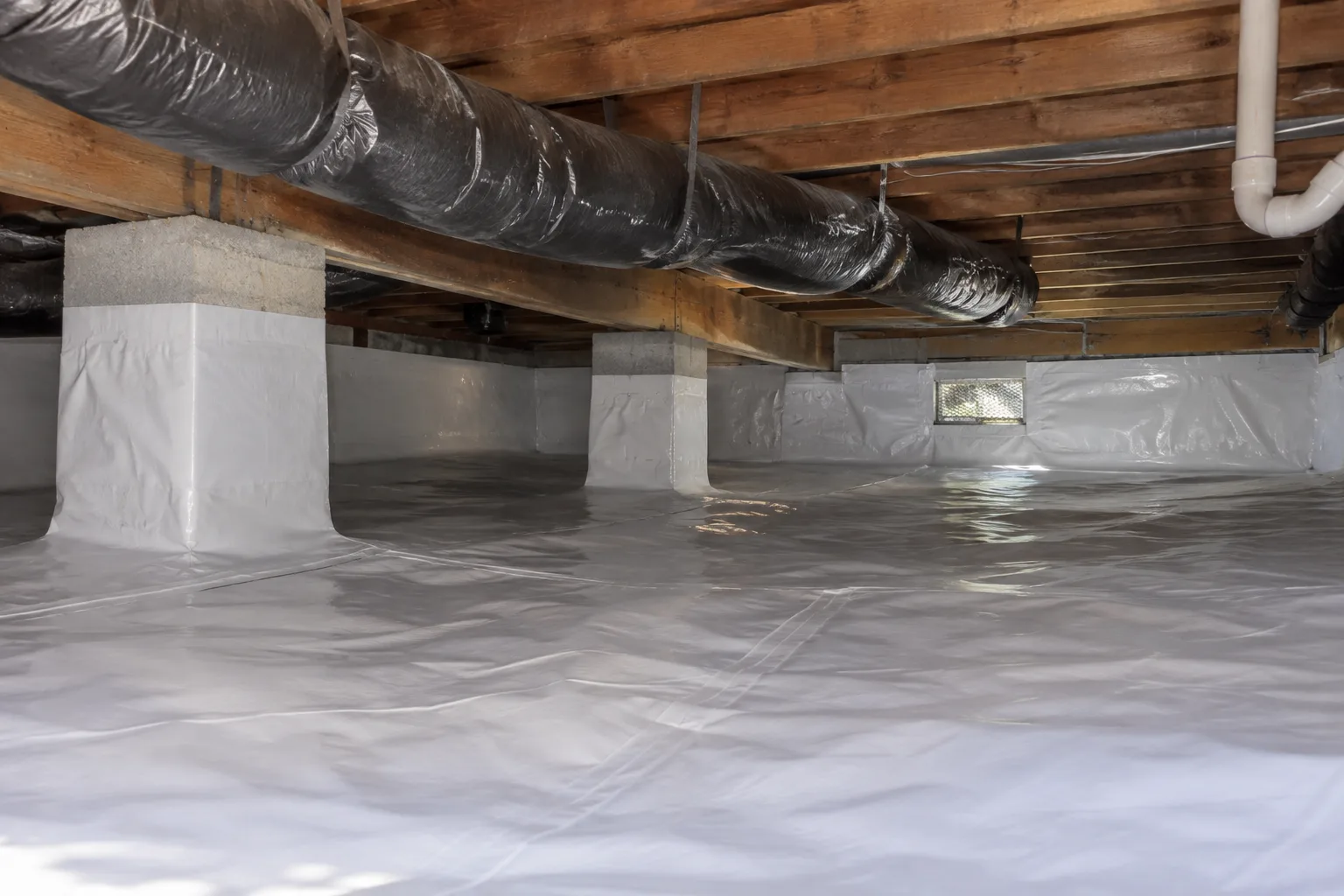 A fully installed vapor moisture barrier lining a crawl space floor and wrapped support piers to block ground moisture and improve energy efficiency.